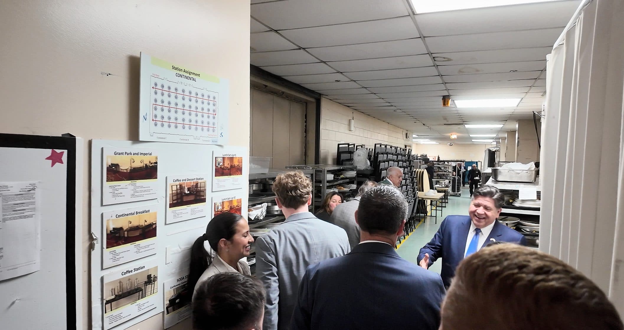 Guests and staff crowd the backstage corridor.