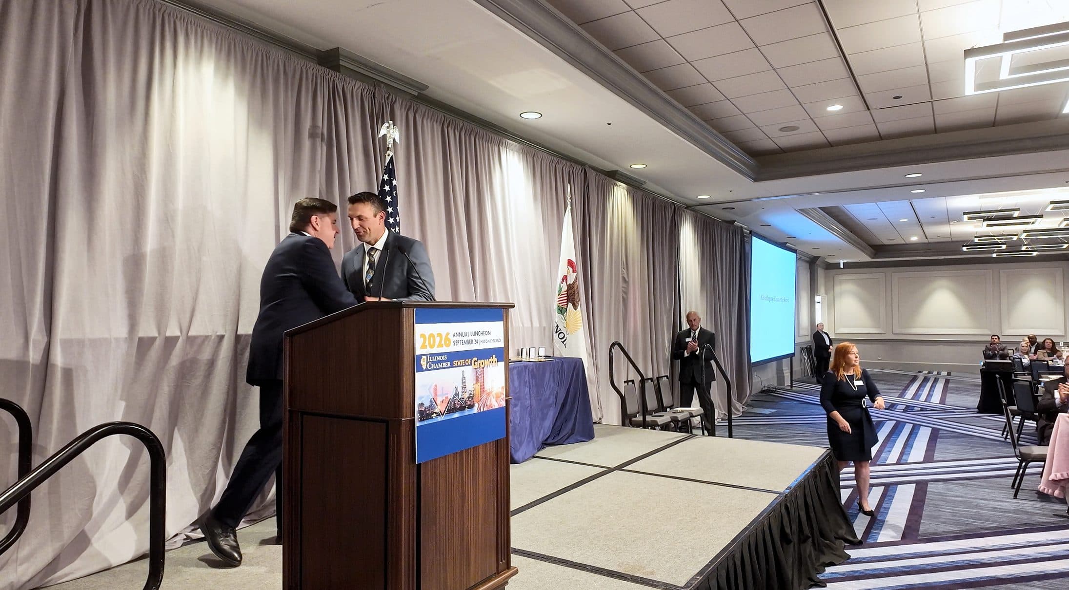 Two men greet each other at the podium.